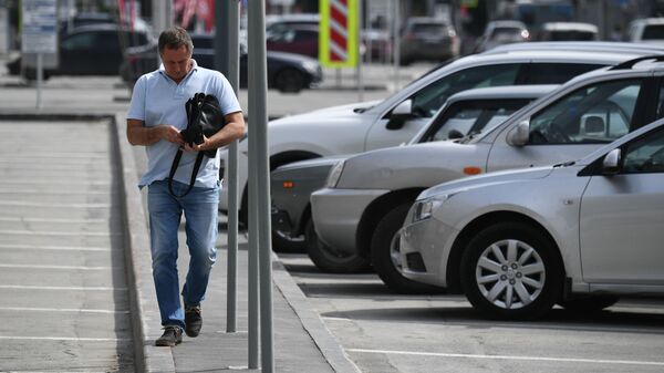 Мужчина идет мимо припаркованных авто. Архивное фото - Sputnik Кыргызстан
