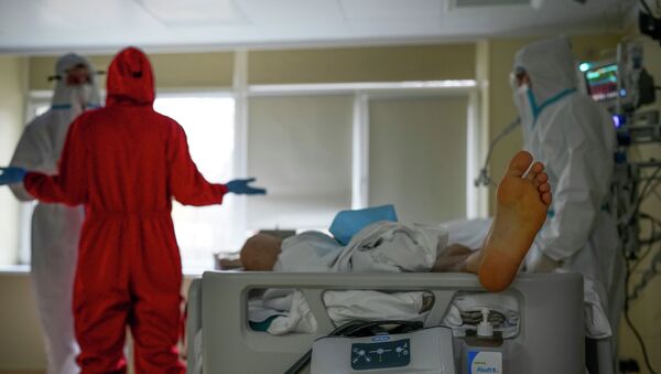 Медицинские работники стоят рядом с пациентом больным COVID-19. Архивное фото - Sputnik Кыргызстан