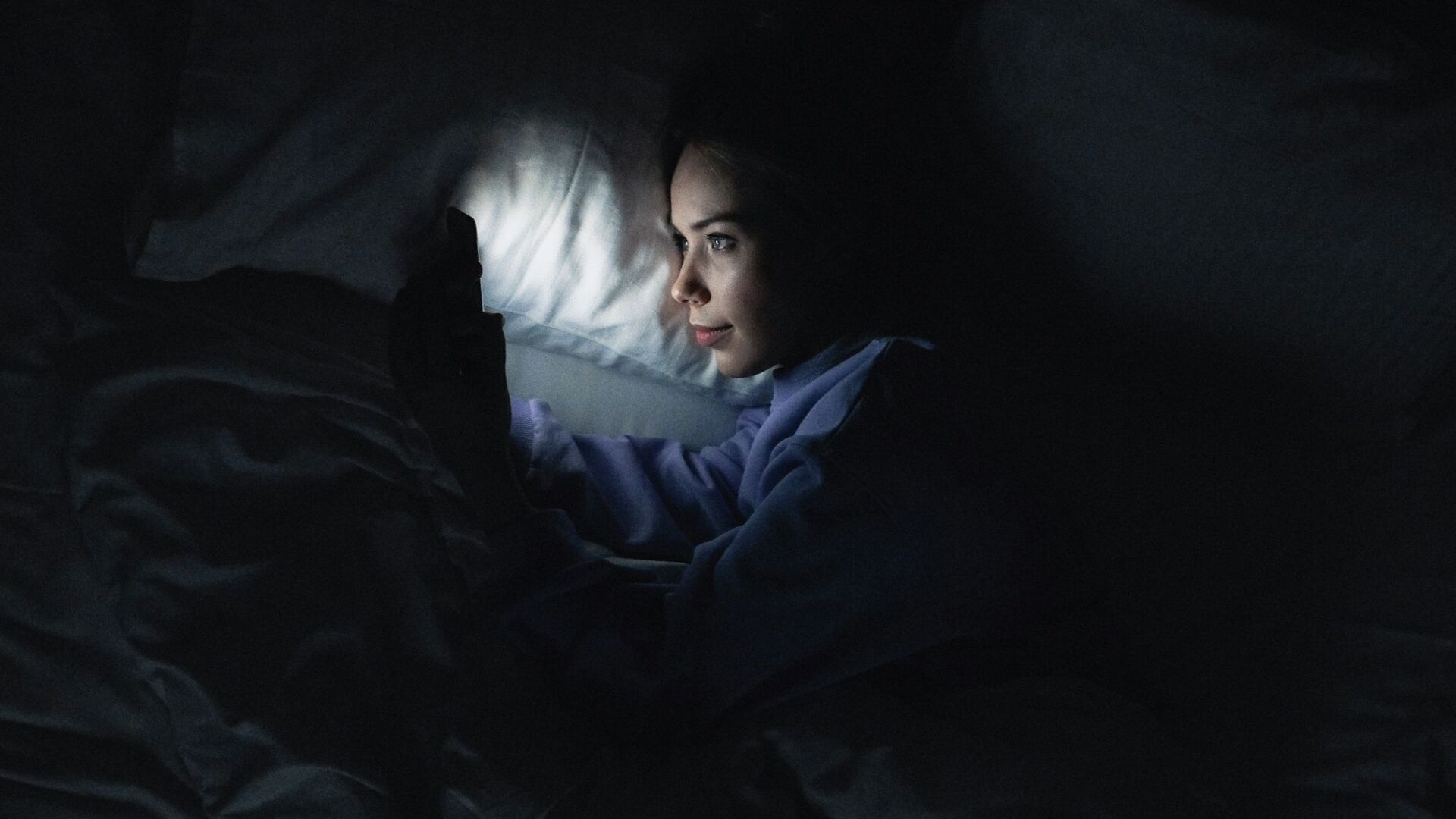 Девушка смотрит видео на смартфоне ночью. Иллюстративное фото - Sputnik Кыргызстан, 1920, 15.01.2022