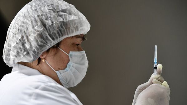 Медицинский работник в пункте вакцинации от коронавируса. Архивное фото - Sputnik Кыргызстан