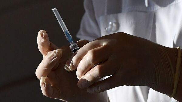 Медицинский работник набирает вакцину в шприц. Архивное фото - Sputnik Кыргызстан
