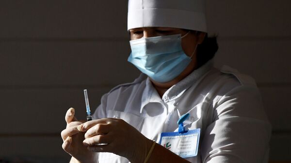 Медсестра набирает в шприц вакцину от COVID-19 - Sputnik Кыргызстан