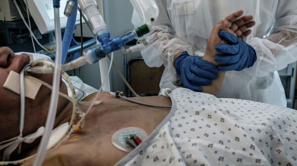 Медсестра ухаживает за пациентом c COVID-19, в отделении интенсивной терапии больницы - Sputnik Кыргызстан