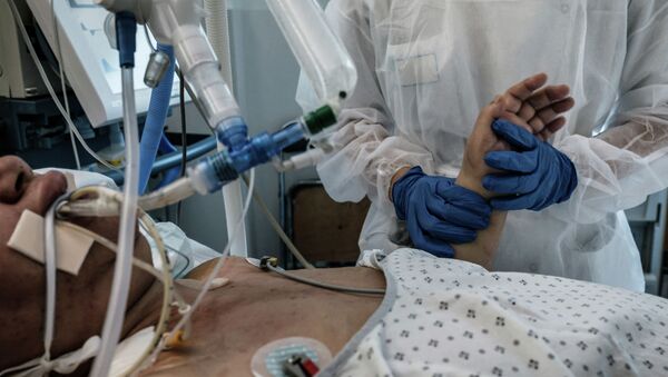 Медсестра ухаживает за пациентом c COVID-19, в отделении интенсивной терапии больницы - Sputnik Кыргызстан