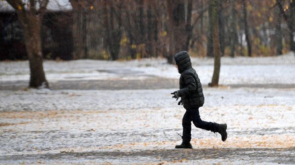 Мальчик бегает по скверу во время снегопада - Sputnik Кыргызстан