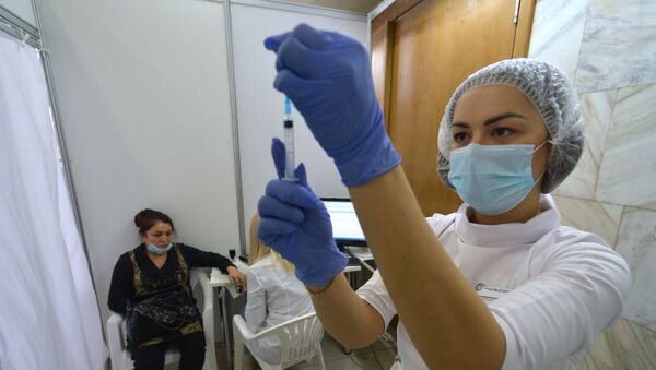 Медицинский работник наполняет шприц для вакцинации от коронавируса. Архивное фото - Sputnik Кыргызстан