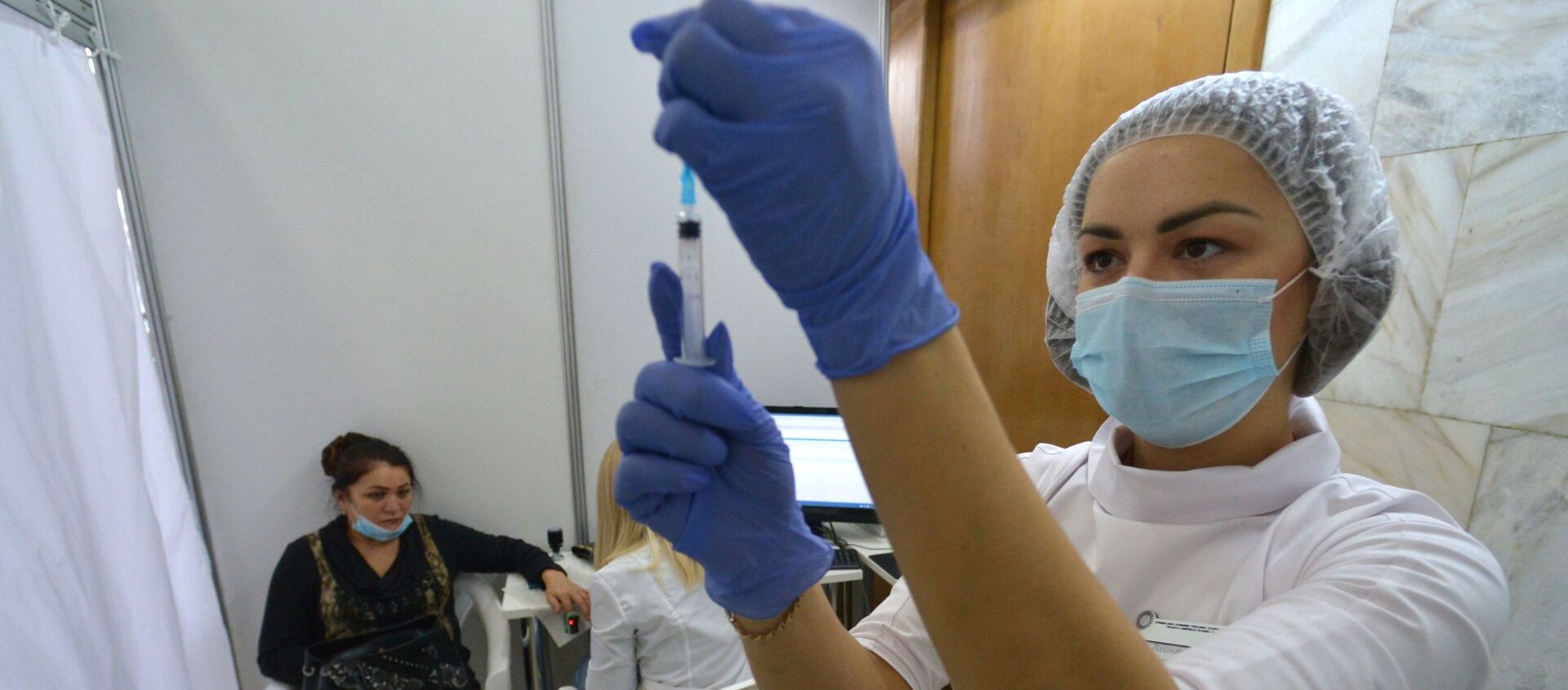 Медицинский работник наполняет шприц для вакцинации от коронавируса. Архивное фото - Sputnik Кыргызстан, 1920, 06.11.2021
