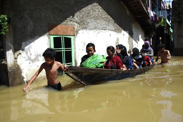 Семья эвакуируется из затопленного дома после сильного дождя в Индонезии - Sputnik Кыргызстан