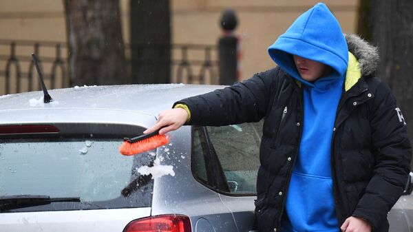Мужчина очищает машину от снега - Sputnik Кыргызстан