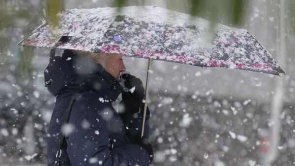 Женщина стоит под зонтом во время снегопада. Архивное фото - Sputnik Кыргызстан