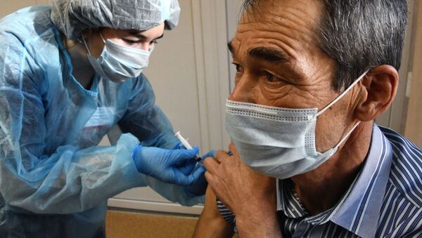 Медицинский работник делает мужчине прививку от коронавируса - Sputnik Кыргызстан