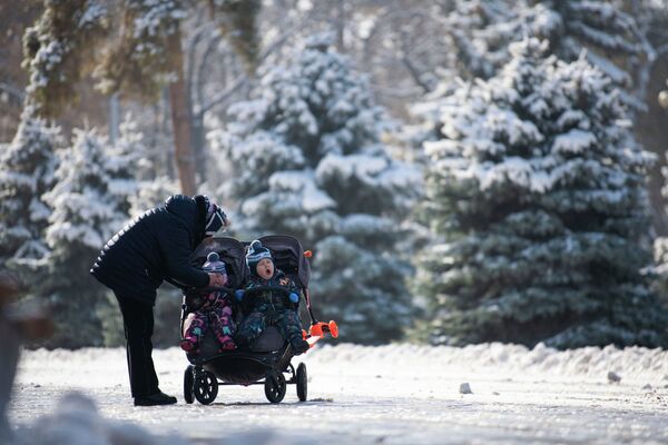 Женщина с детьми на одной из улиц Бишкека после сильного снегопада - Sputnik Кыргызстан