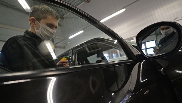 Сотрудник СТО обрабатывает стекло автомобиля. Архивное фото - Sputnik Кыргызстан