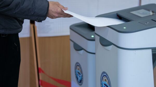 Избиратель опускает бюллетень в электронную урну - Sputnik Кыргызстан