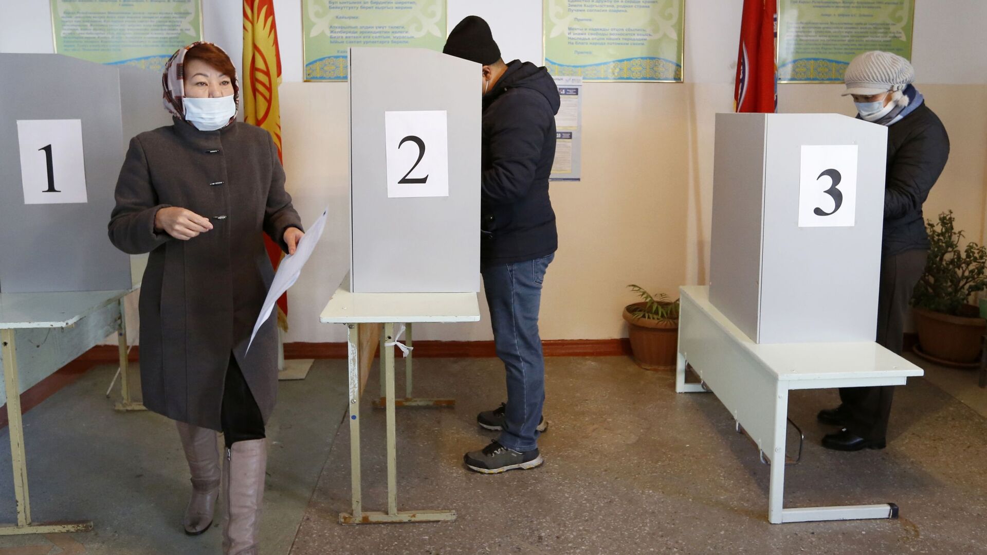 Люди голосуют на избирательном участке во время парламентских выборов в Кыргызстане - Sputnik Кыргызстан, 1920, 29.11.2021