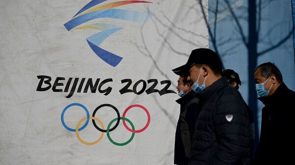 Люди проходят мимо логотипа Зимних Олимпийских игр 2022 года в Пекине - Sputnik Кыргызстан