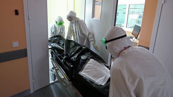 Медицинские сотрудники перевозят тело человека, скончавшегося от COVID-19 - Sputnik Кыргызстан