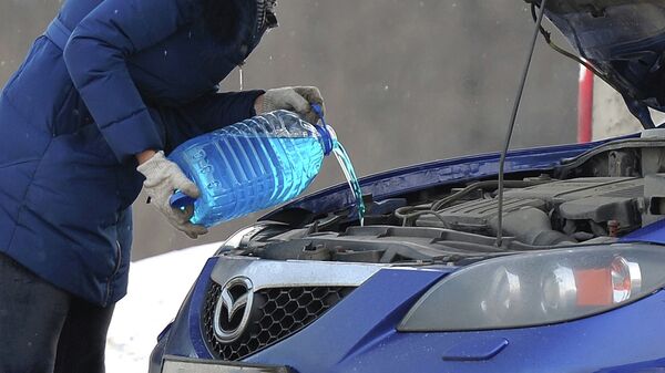 Женщина заливает незамерзающую жидкость в авто - Sputnik Кыргызстан