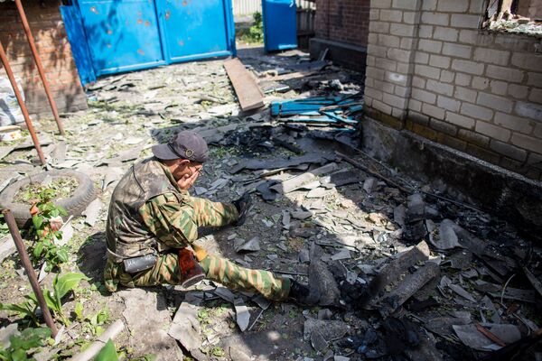 Ополченец, вернувшийся в свой дом в поселке Семеновка под Славянском, разрушенный в результате попадания снаряда во время ночного обстрела украинскими военными - Sputnik Кыргызстан