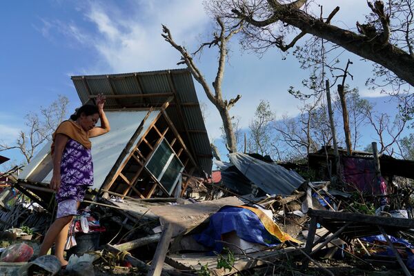 Женщина возле своего дома, разрушенного тайфуном Рай в провинции Себу (Филиппины). По последним данным, погибли 208 человек, десятки пропали без вести. - Sputnik Кыргызстан