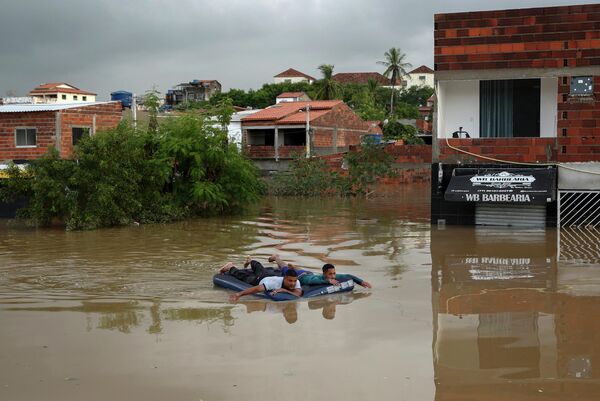 Мужчины на надувном матрасе во время наводнений в Бразилии - Sputnik Кыргызстан