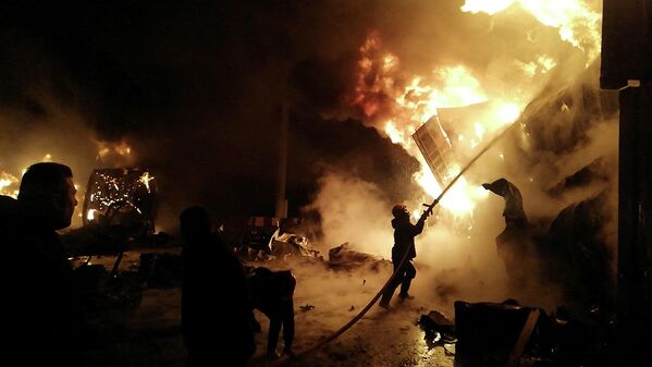 Пожарный тушит пламя после ракетного удара Израиля по складу в Сирии - Sputnik Кыргызстан