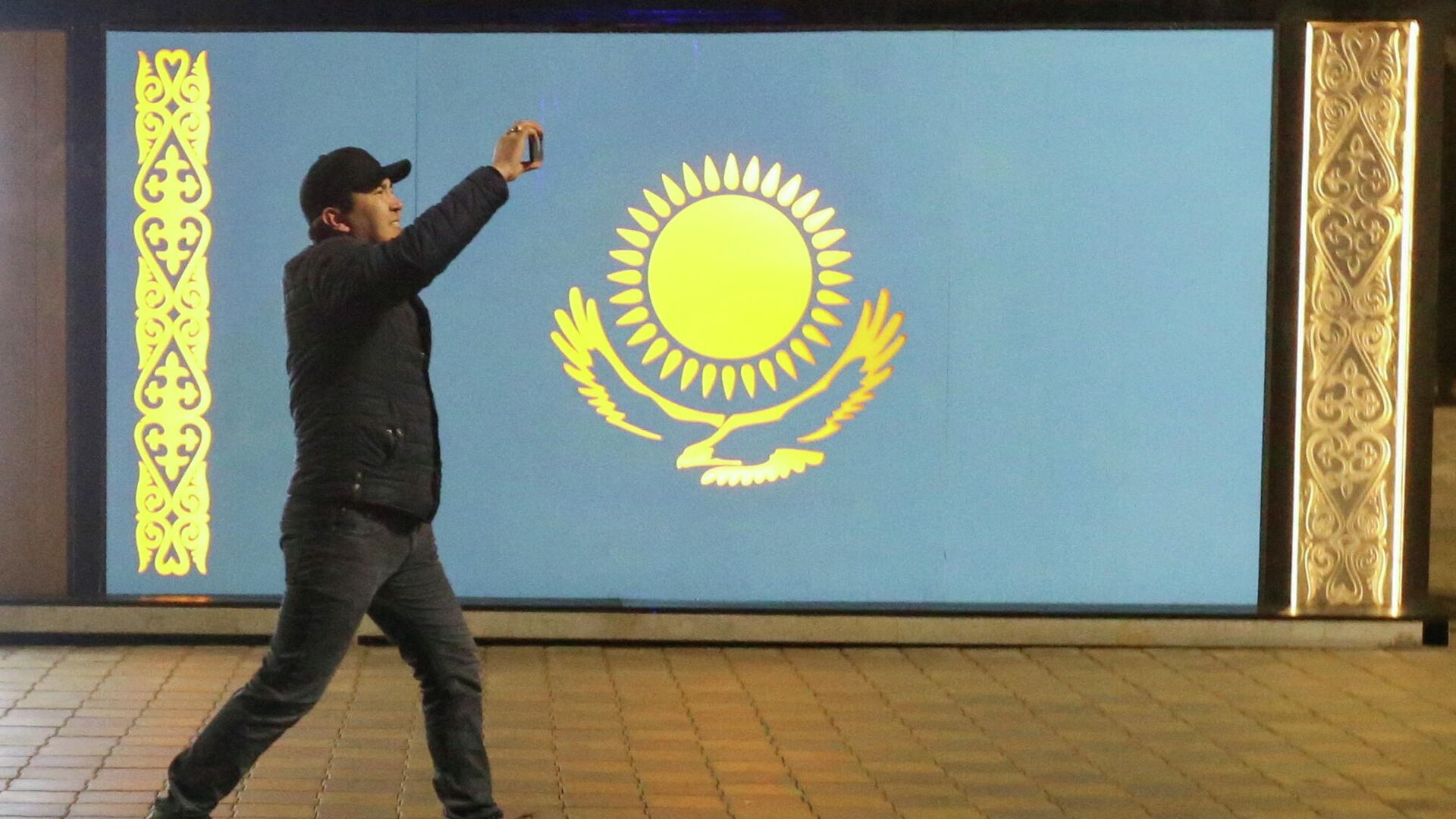 Мужчина на фоне флага РК во время беспорядков в Алматы - Sputnik Кыргызстан, 1920, 16.01.2022