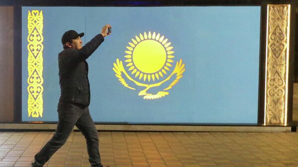 Мужчина на фоне флага РК во время беспорядков в Алматы - Sputnik Кыргызстан