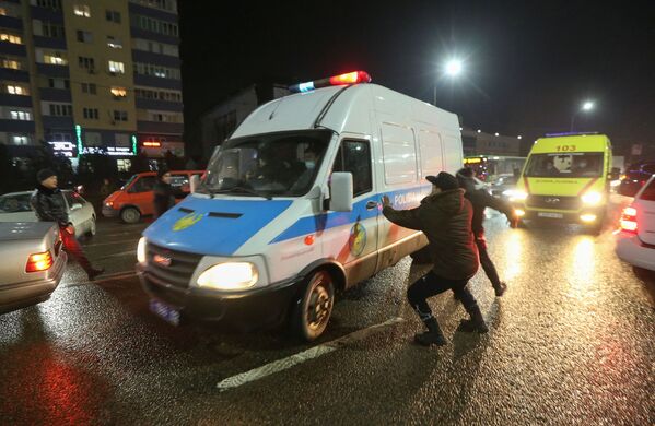 Митинги в Казахстане начались сразу после Нового года. На фото люди нападают на полицейский микроавтобус. - Sputnik Кыргызстан