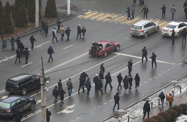 Акции протеста проходят во многих городах Казахстана, в том числе в Алматы. На фото митингующие идут по улице.  - Sputnik Кыргызстан