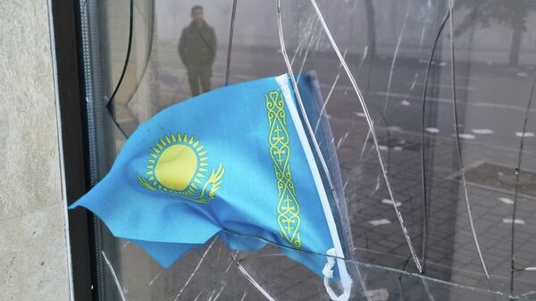 Государственный флаг Казахстана на разбитом окне отделения Kaspi Bank в Алматы. Архивное фото - Sputnik Кыргызстан