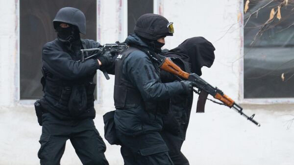 Полицейские с задержанным человеком во время беспорядков в Алма-Ате. Архивное фото - Sputnik Кыргызстан