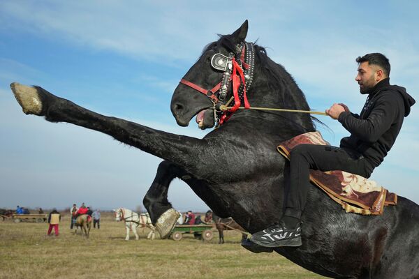Мужчина демонстрирует навыки верховой езды во время празднования Крещения Господня в деревне Пьетросани (Румыния) - Sputnik Кыргызстан