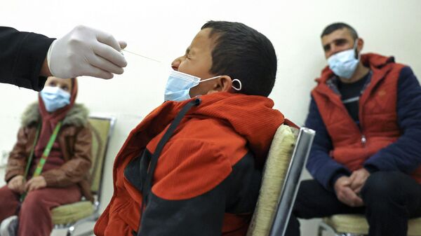 Медицинский работник берет образец мазка у ребенка для тестирования на COVID-19 - Sputnik Кыргызстан