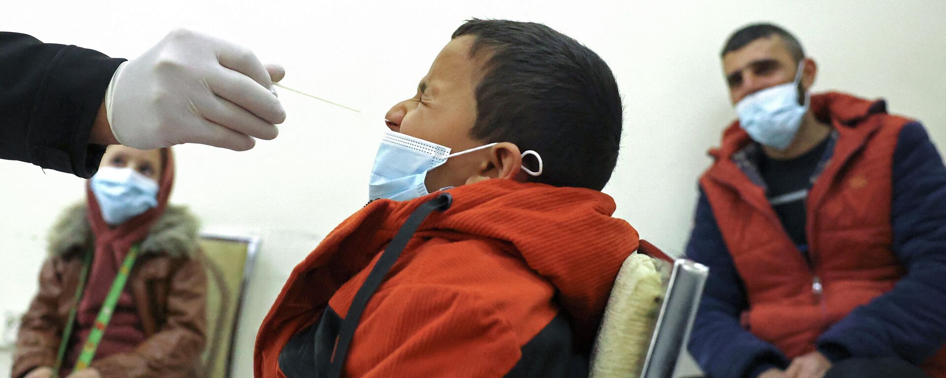 Медицинский работник берет образец мазка у ребенка для тестирования на COVID-19 - Sputnik Кыргызстан, 1920, 10.01.2022