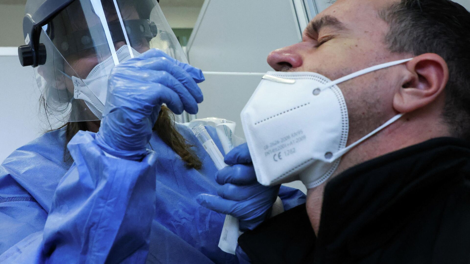 Медик берет образец мазка у мужчины для тестирования на COVID-19 - Sputnik Кыргызстан, 1920, 13.01.2022