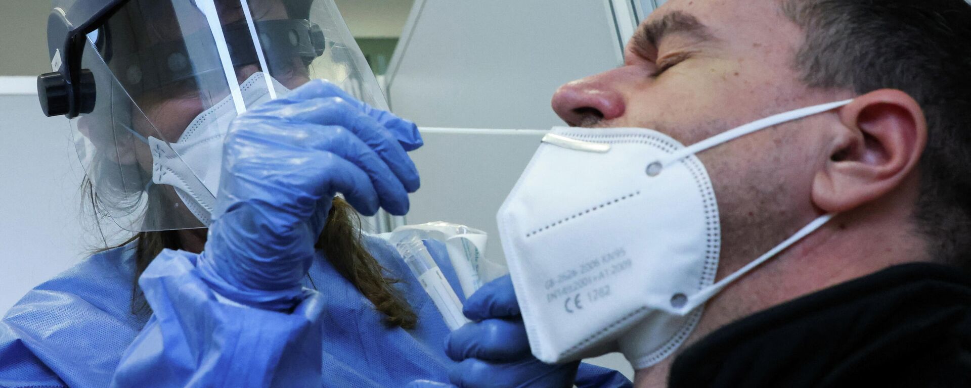 Медик берет образец мазка у мужчины для тестирования на COVID-19 - Sputnik Кыргызстан, 1920, 13.01.2022