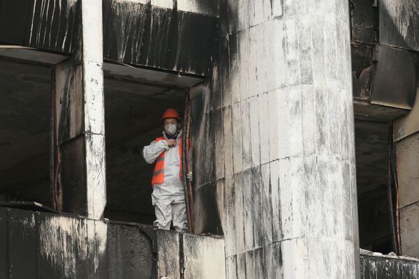 Участники беспорядков подожгли здание, оно практически полностью выгорело изнутри. На фото: рабочий во время восстановительных работ. - Sputnik Кыргызстан
