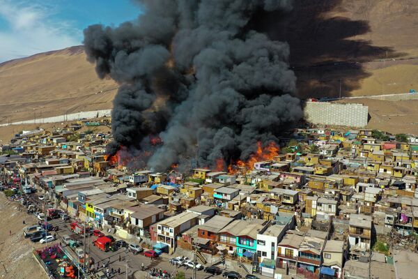 Крупный пожар уничтожил по меньшей мере 100 домов в городе Икике на севере Чили. Около 400 человек остались без крова. - Sputnik Кыргызстан