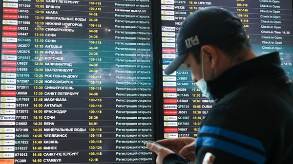 Мужчина возле электронного табло вылетов в аэропорту. Архивное фото - Sputnik Кыргызстан