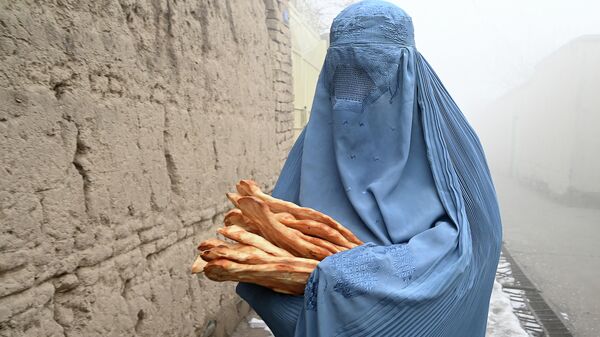 Женщина в Кабуле несет домой бесплатный хлеб. Архивное фото - Sputnik Кыргызстан