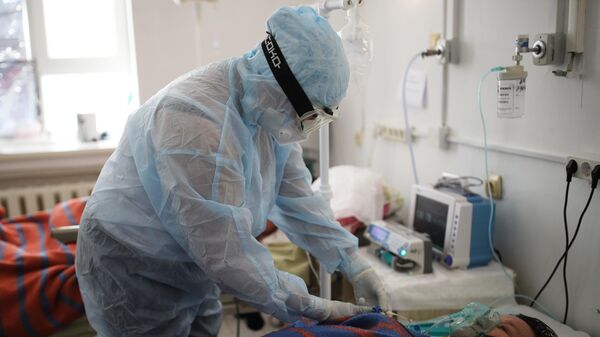 Медицинский работник у кровати пациента в реанимационном отделении. Архивное фото - Sputnik Кыргызстан