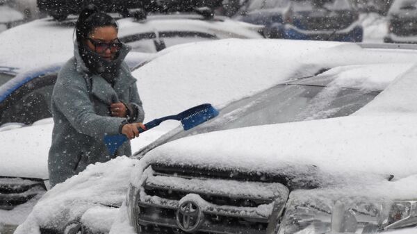 Женщина очищает автомобиль от снега. Архивное фото - Sputnik Кыргызстан