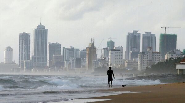 Мужчина идет по пляжу в столице Шри-Ланки, городе Коломбо - Sputnik Кыргызстан
