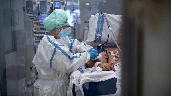 Медицинский работник оказывает помощь пациенту с COVID-19 в больнице - Sputnik Кыргызстан