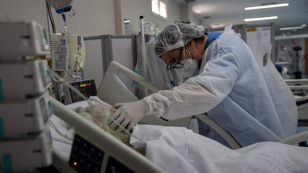 Медициналык кызматкер COVID-19 менен ооруган бейтапты ооруканада дарылап жатат - Sputnik Кыргызстан