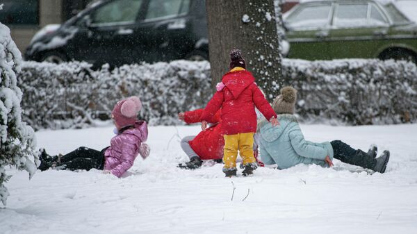 Дети играют на снегу во время снегопада в Бишкеке - Sputnik Кыргызстан