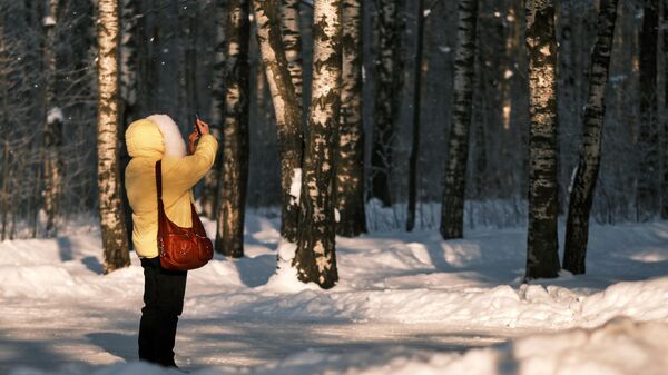 Девушка фотографирует деревья в парке. Архивное фото  - Sputnik Кыргызстан