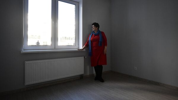 Женщина стоит у окна в квартире. Архивное фото - Sputnik Кыргызстан
