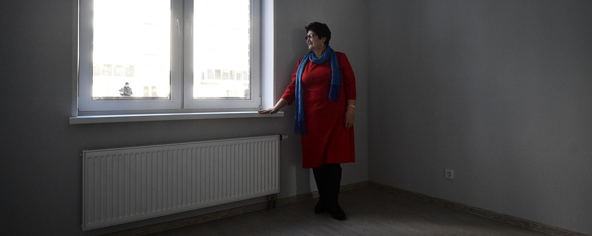 Женщина стоит у окна в квартире. Архивное фото - Sputnik Кыргызстан, 1920, 21.02.2022